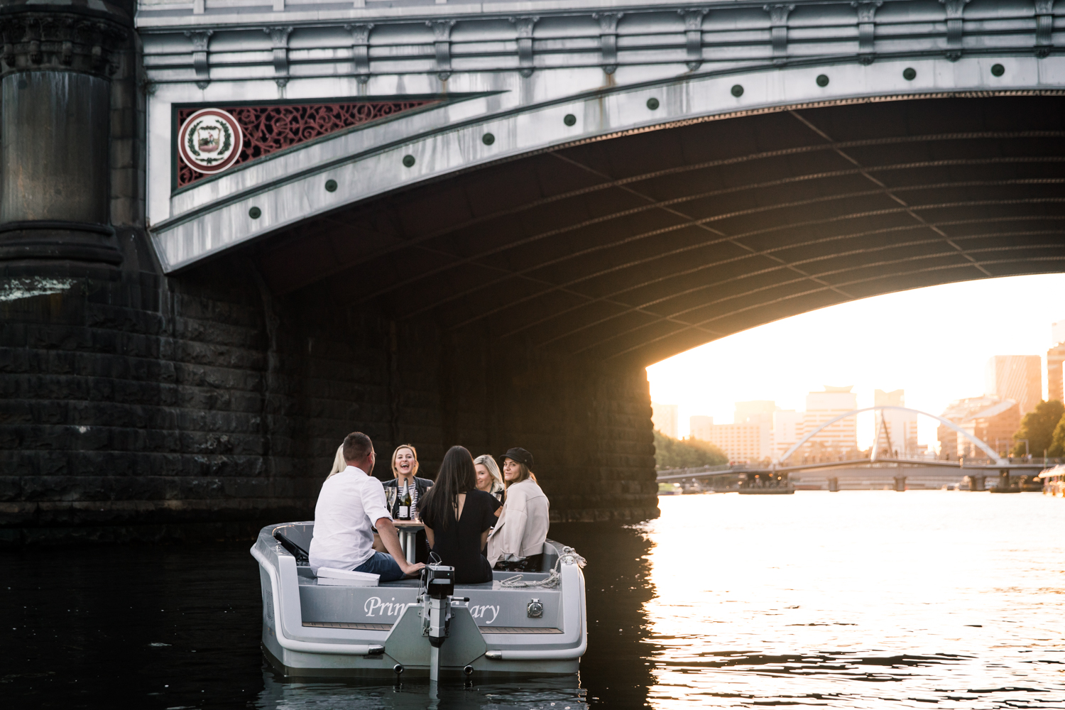 Small electric boat sailing under low bridge