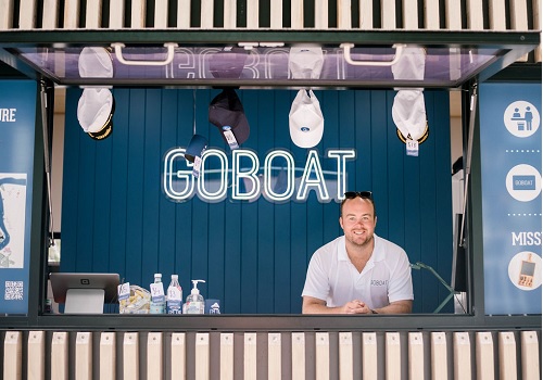 Man standing in front of a GoBoat sign